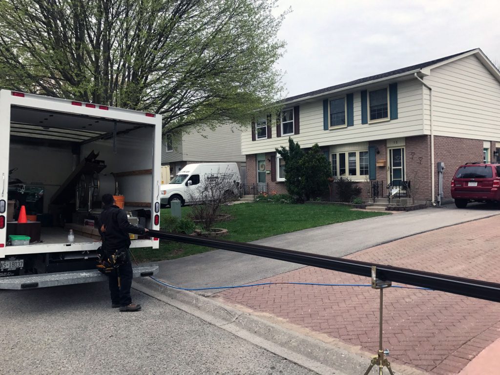 Only Eavestroughs truck-mounted machine roll-forming seamless aluminum eavestrough on site at a London, Ontario home
