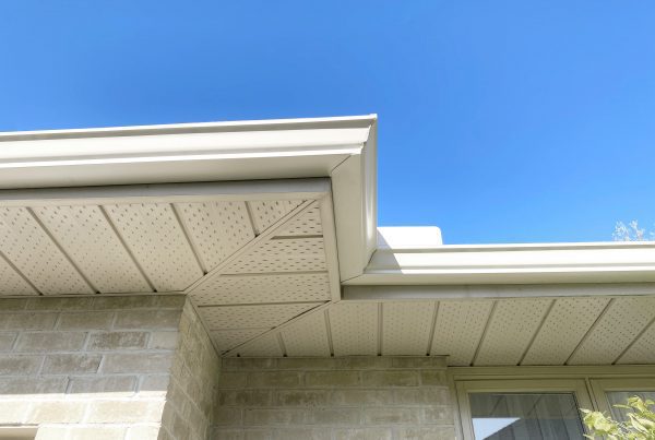 Seamless gutters installed professionally looking from below against blue sky