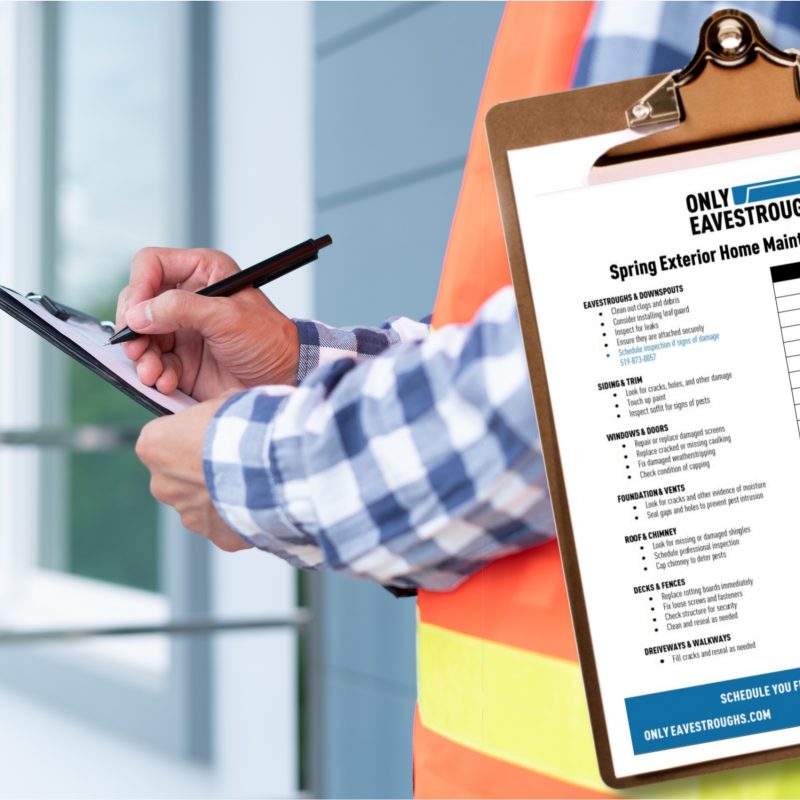 Person in orange vest holding clipboard is completing exterior home maintenance checklist