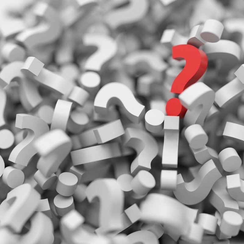 Pile of white 3D question marks with one red one