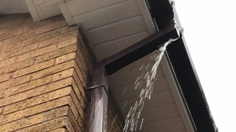 Water pouring out of a failed eavestrough corner joint on a London, Ontario home